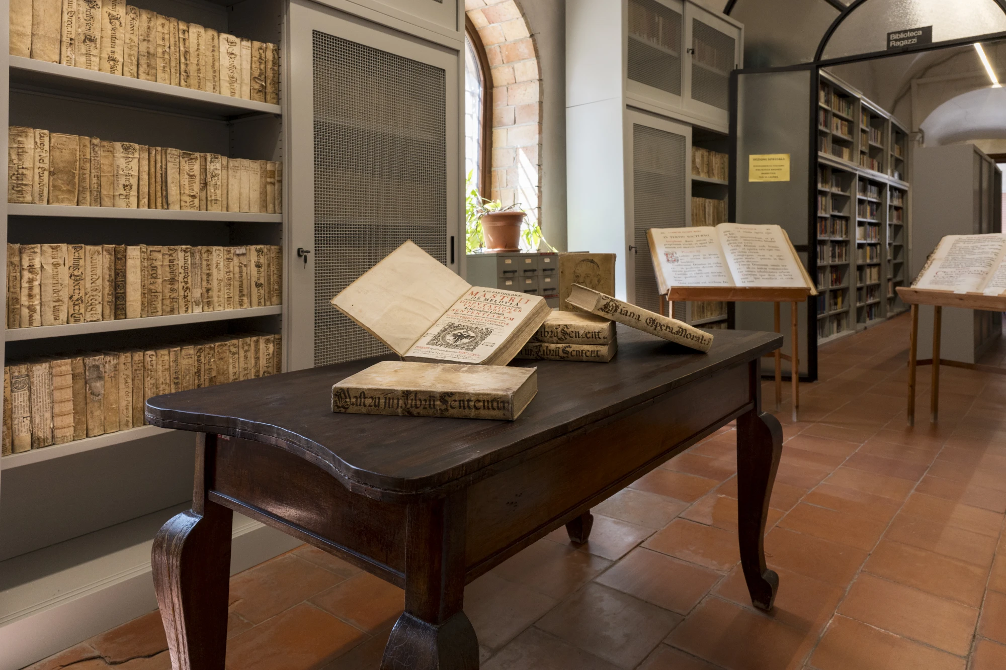 Interno della Biblioteca Comunale di Ciminna - Francesco Brancato con libri antichi su un tavolo e scaffali storici